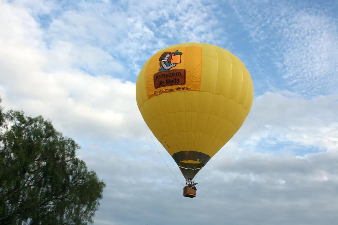 Balão amarelo com marca de cliente no céu azul