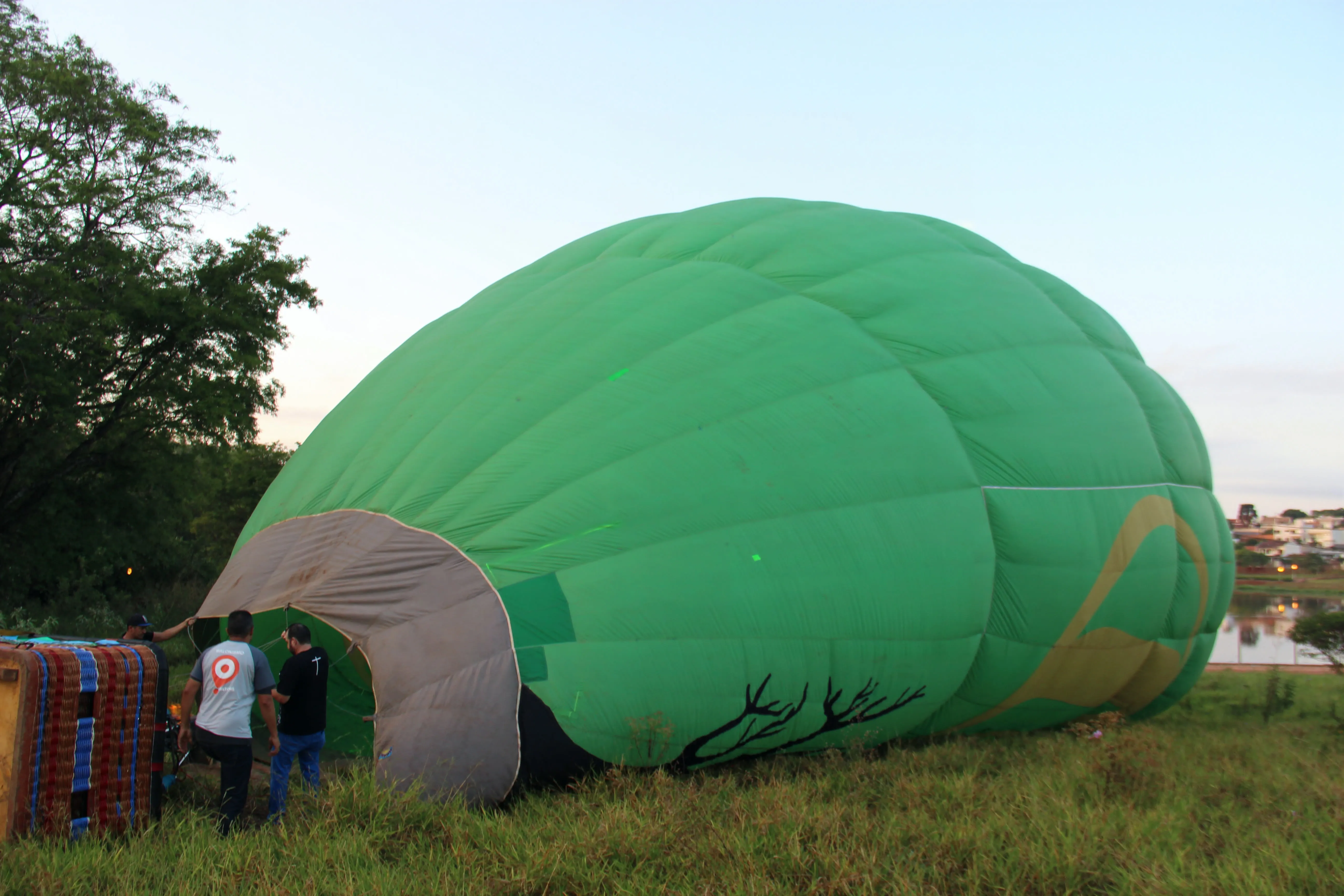 Balão verde sendo inflado no chão, ao amanhecer